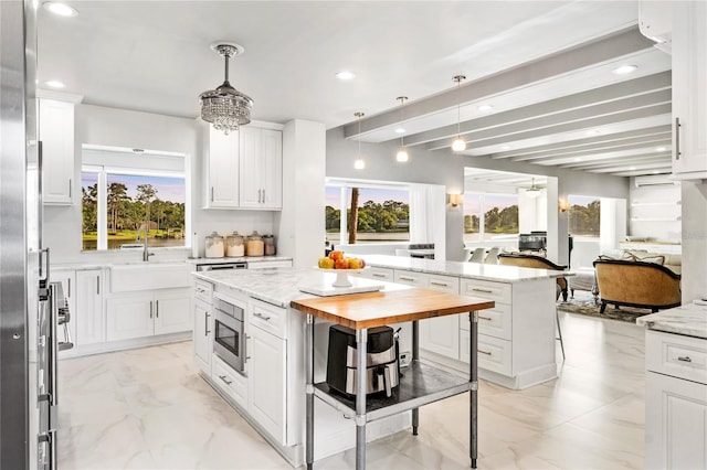 kitchen with a center island, a wealth of natural light, wood counters, and pendant lighting