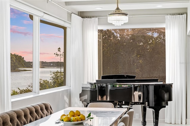 dining space featuring a notable chandelier and a water view