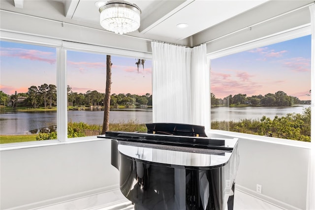 dining space with a notable chandelier and a water view