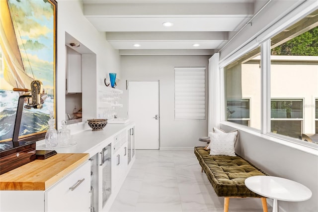 interior space featuring beam ceiling, tile floors, and vanity