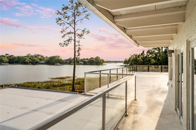 patio terrace at dusk featuring a water view