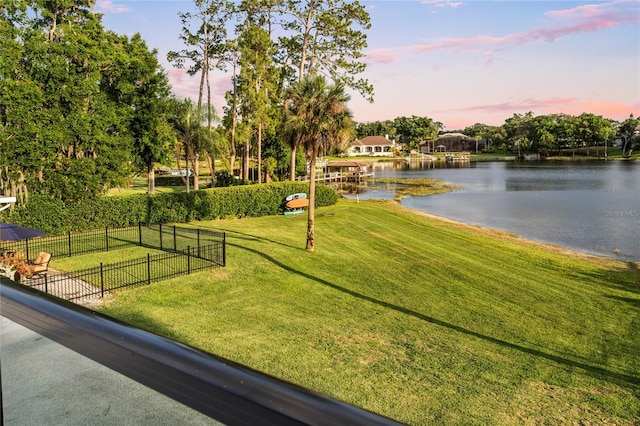 surrounding community with a yard and a water view