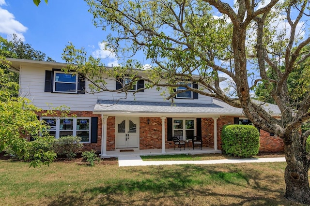 view of front of property featuring covered porch and a front lawn