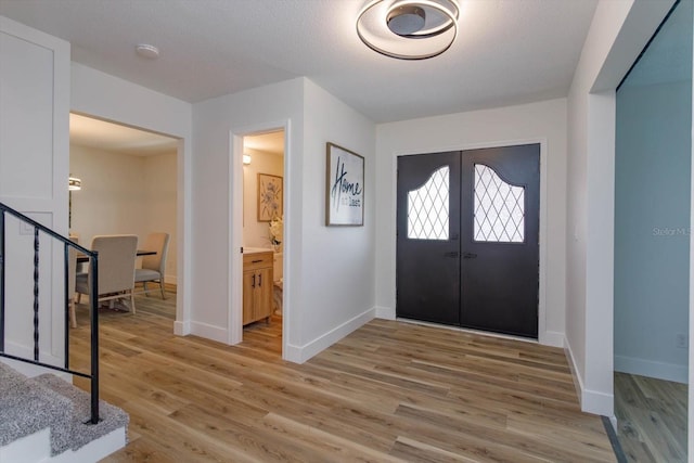 foyer entrance featuring light wood-type flooring and french doors