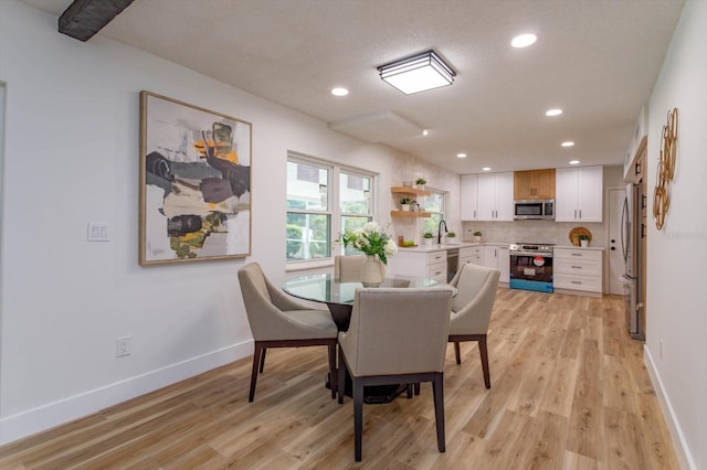 dining area with sink and light hardwood / wood-style floors