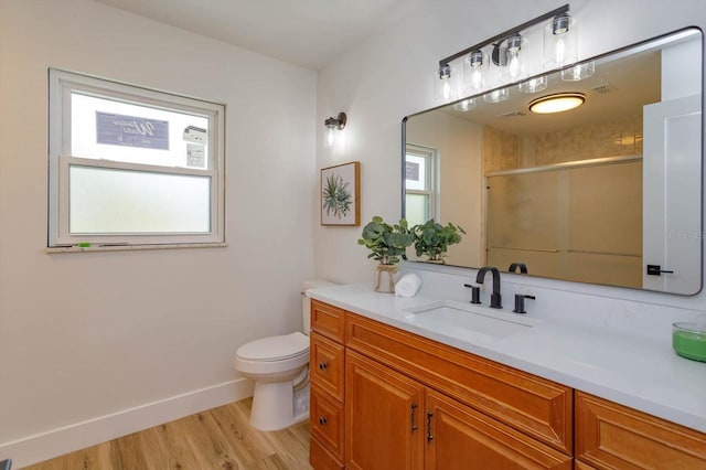 bathroom with a shower with door, vanity, hardwood / wood-style flooring, and a healthy amount of sunlight