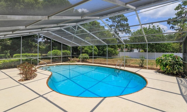 view of swimming pool featuring a patio area and glass enclosure