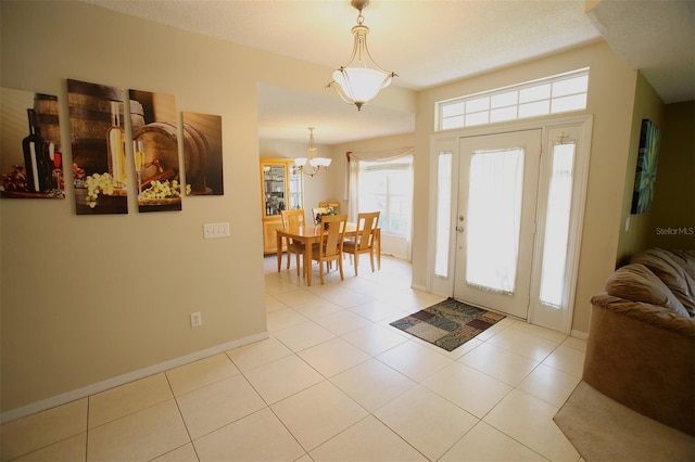 foyer entrance with a chandelier and light tile floors