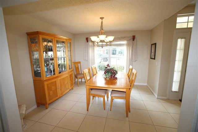 tiled dining area featuring a notable chandelier and a textured ceiling