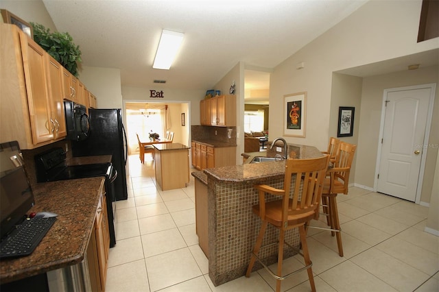 kitchen featuring lofted ceiling, dark stone counters, sink, range with electric cooktop, and light tile floors