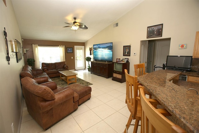 living room with vaulted ceiling, ceiling fan, and light tile flooring