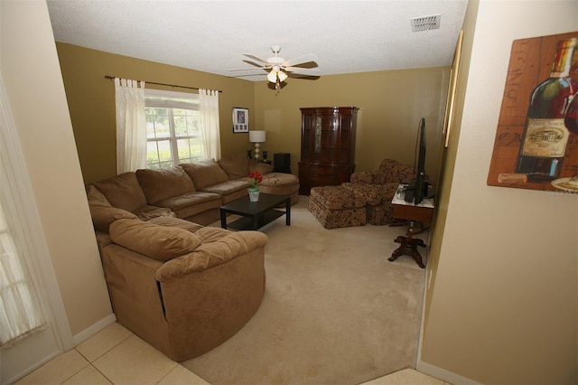 living room with ceiling fan, tile floors, and a textured ceiling