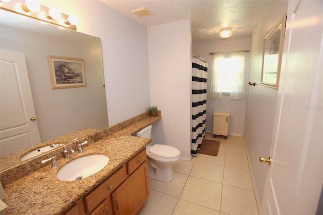 bathroom featuring tile flooring, oversized vanity, toilet, and a textured ceiling