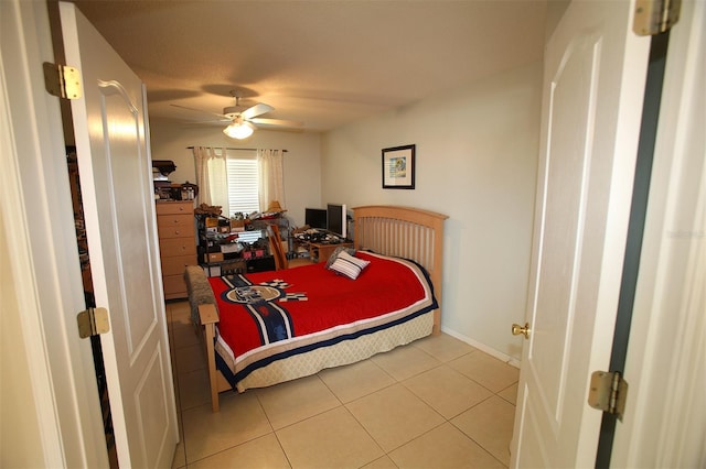 tiled bedroom featuring ceiling fan