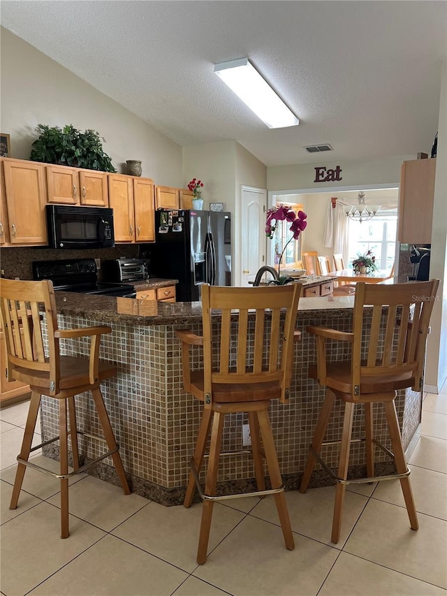 1201 Thornbury Ct, Winter Garden, FL 34787 - kitchen featuring a textured ceiling, visible vents, dark countertops, light tile patterned floors, and black appliances