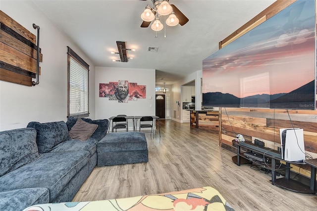 living room featuring wood-type flooring and ceiling fan