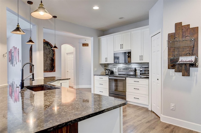 kitchen featuring decorative light fixtures, light hardwood / wood-style floors, tasteful backsplash, white cabinetry, and range with electric cooktop