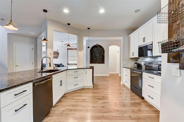 kitchen featuring pendant lighting, tasteful backsplash, light wood-type flooring, and stainless steel appliances