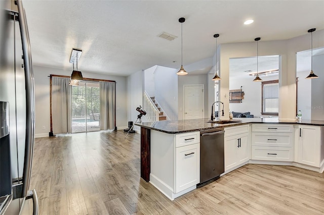 kitchen with hanging light fixtures, light wood-type flooring, dishwasher, and white cabinets