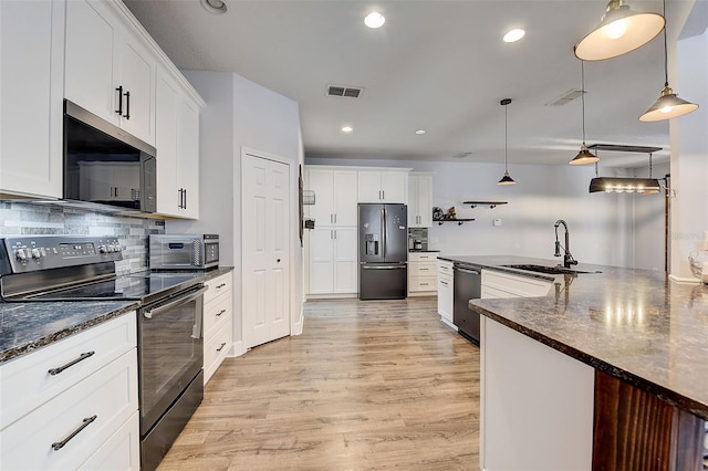 kitchen featuring pendant lighting, light hardwood / wood-style flooring, white cabinetry, stainless steel appliances, and tasteful backsplash