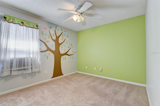 carpeted empty room with ceiling fan and a textured ceiling