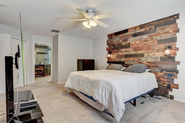 bedroom featuring a textured ceiling, carpet floors, ceiling fan, and wooden walls