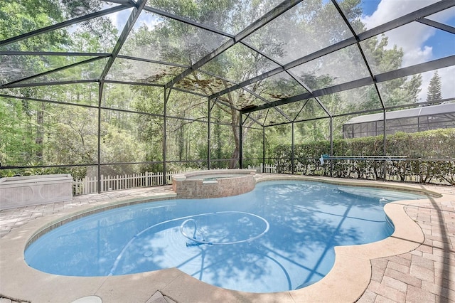 view of pool with glass enclosure and an in ground hot tub