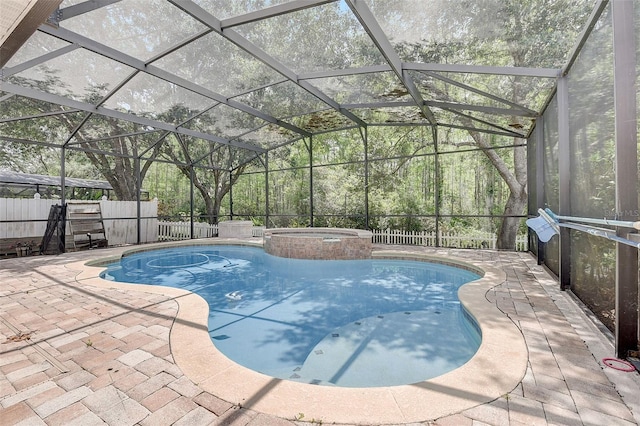 view of pool featuring a patio, glass enclosure, and an in ground hot tub