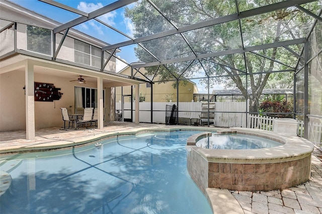 view of swimming pool featuring ceiling fan, an in ground hot tub, a lanai, and a patio