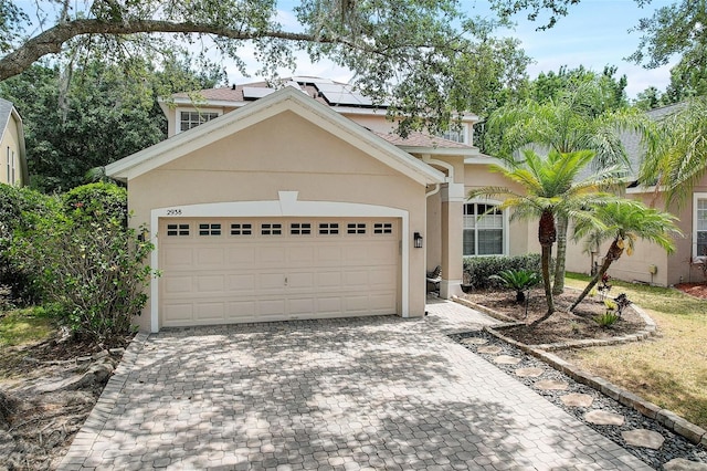 view of front of house featuring a garage and solar panels