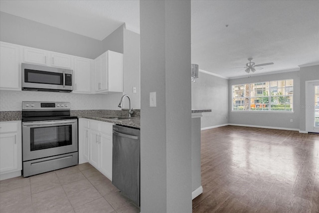 kitchen featuring dark stone counters, sink, ceiling fan, white cabinetry, and stainless steel appliances