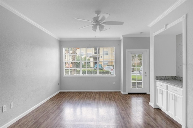 unfurnished dining area featuring dark hardwood / wood-style flooring, ceiling fan, and crown molding