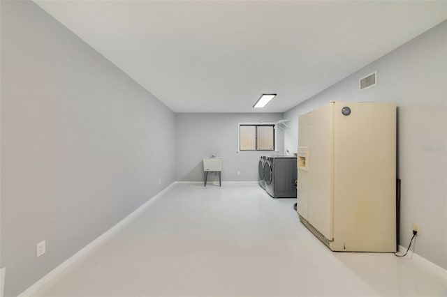 basement featuring white fridge and washer and clothes dryer