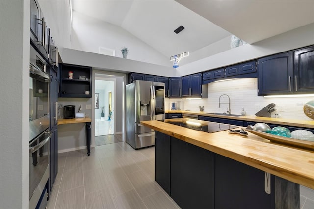 kitchen with wood counters, sink, blue cabinets, and stainless steel refrigerator with ice dispenser