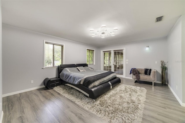 bedroom with access to outside and hardwood / wood-style floors