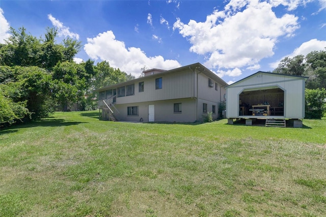 rear view of house with a yard, a garage, and an outdoor structure