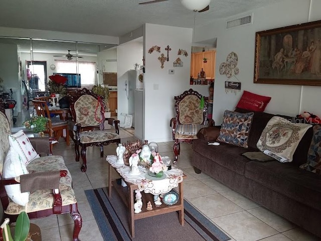 living room with ceiling fan and light tile flooring