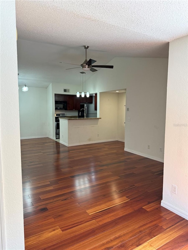 unfurnished living room featuring dark wood-style flooring, a ceiling fan, vaulted ceiling, a textured ceiling, and baseboards