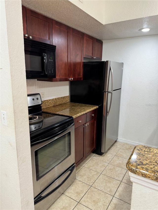 kitchen with light tile patterned floors, a textured wall, a textured ceiling, appliances with stainless steel finishes, and reddish brown cabinets