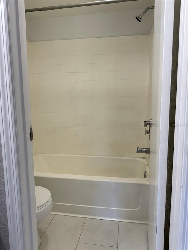 bathroom with bathing tub / shower combination, toilet, and tile patterned floors