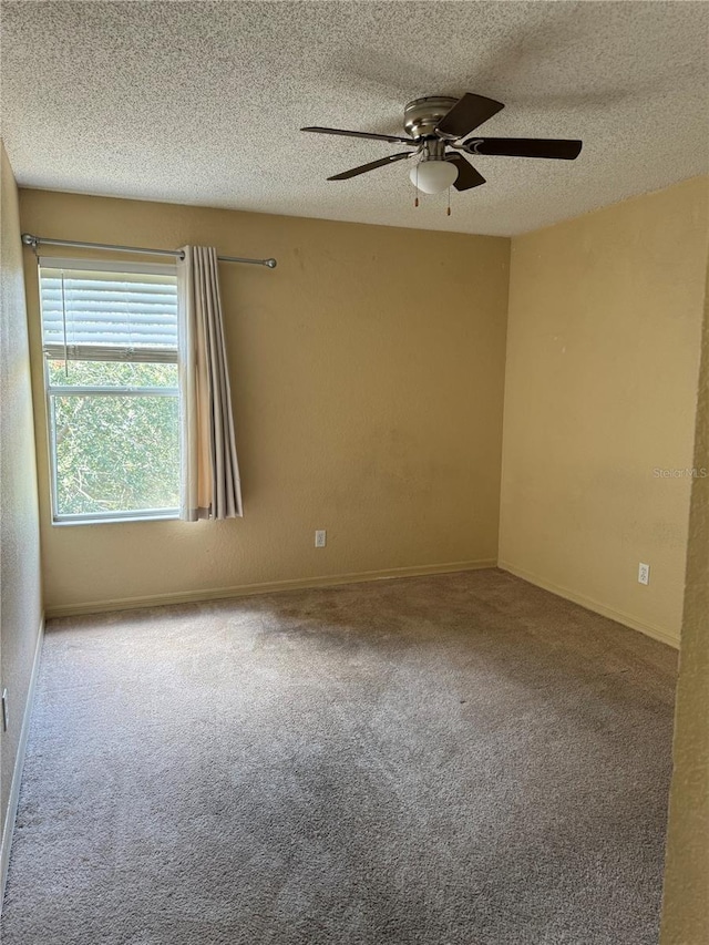 carpeted empty room with a textured ceiling, ceiling fan, and baseboards