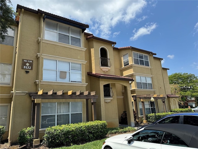 exterior space featuring a tiled roof and stucco siding