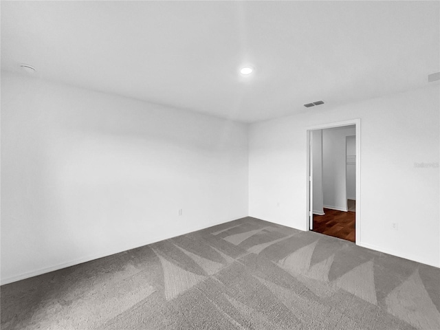 empty room with dark colored carpet