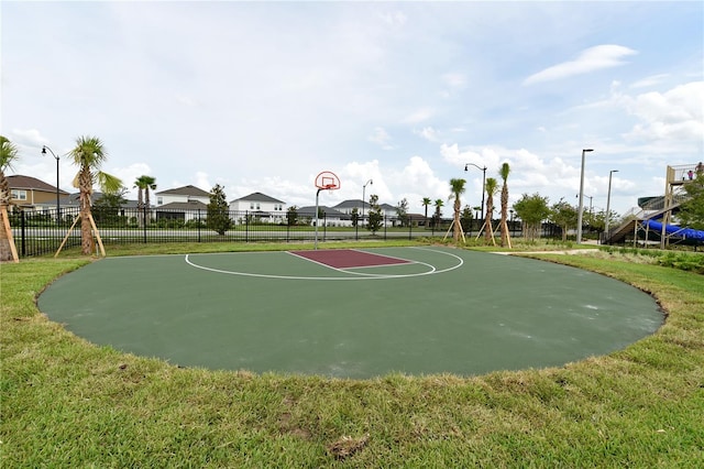 view of sport court featuring a lawn