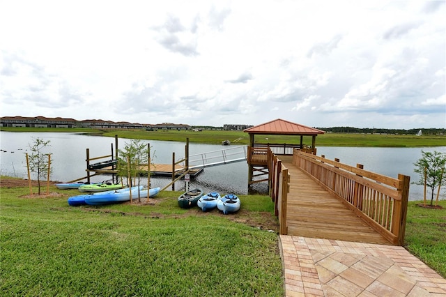 dock area with a lawn, a water view, and a gazebo