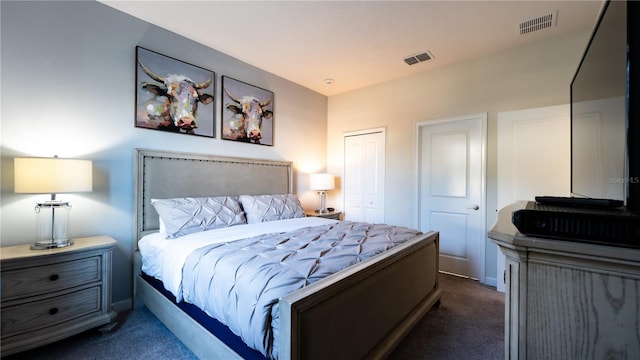 bedroom with a closet and dark carpet