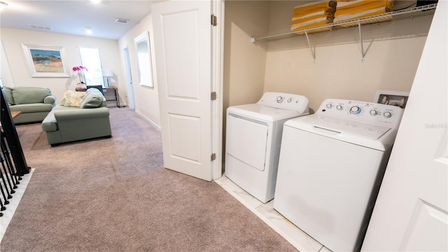 clothes washing area with light colored carpet and independent washer and dryer