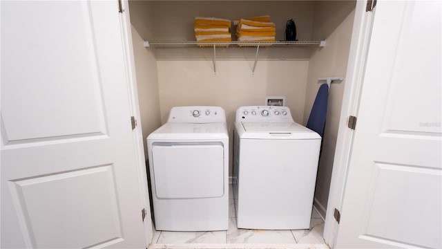 laundry area with hookup for a washing machine, separate washer and dryer, and light tile floors