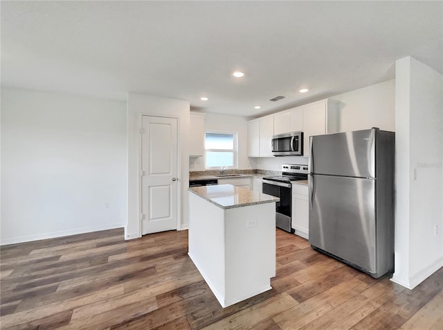 kitchen featuring wood-type flooring, a center island, sink, and stainless steel appliances