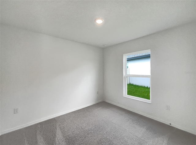 unfurnished room featuring a textured ceiling and carpet